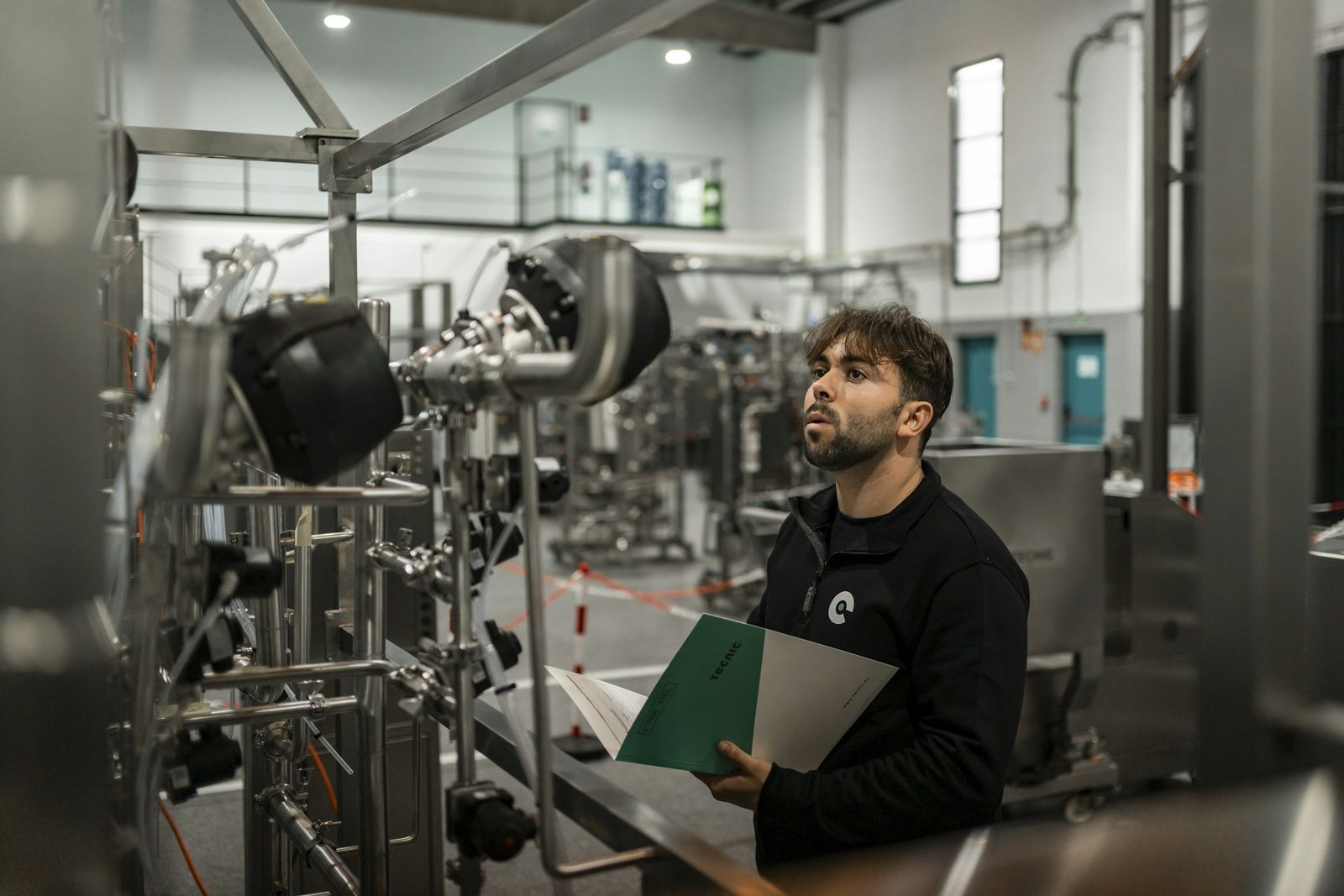 Un técnico revisa una planta de proceso con la tablilla en la mano