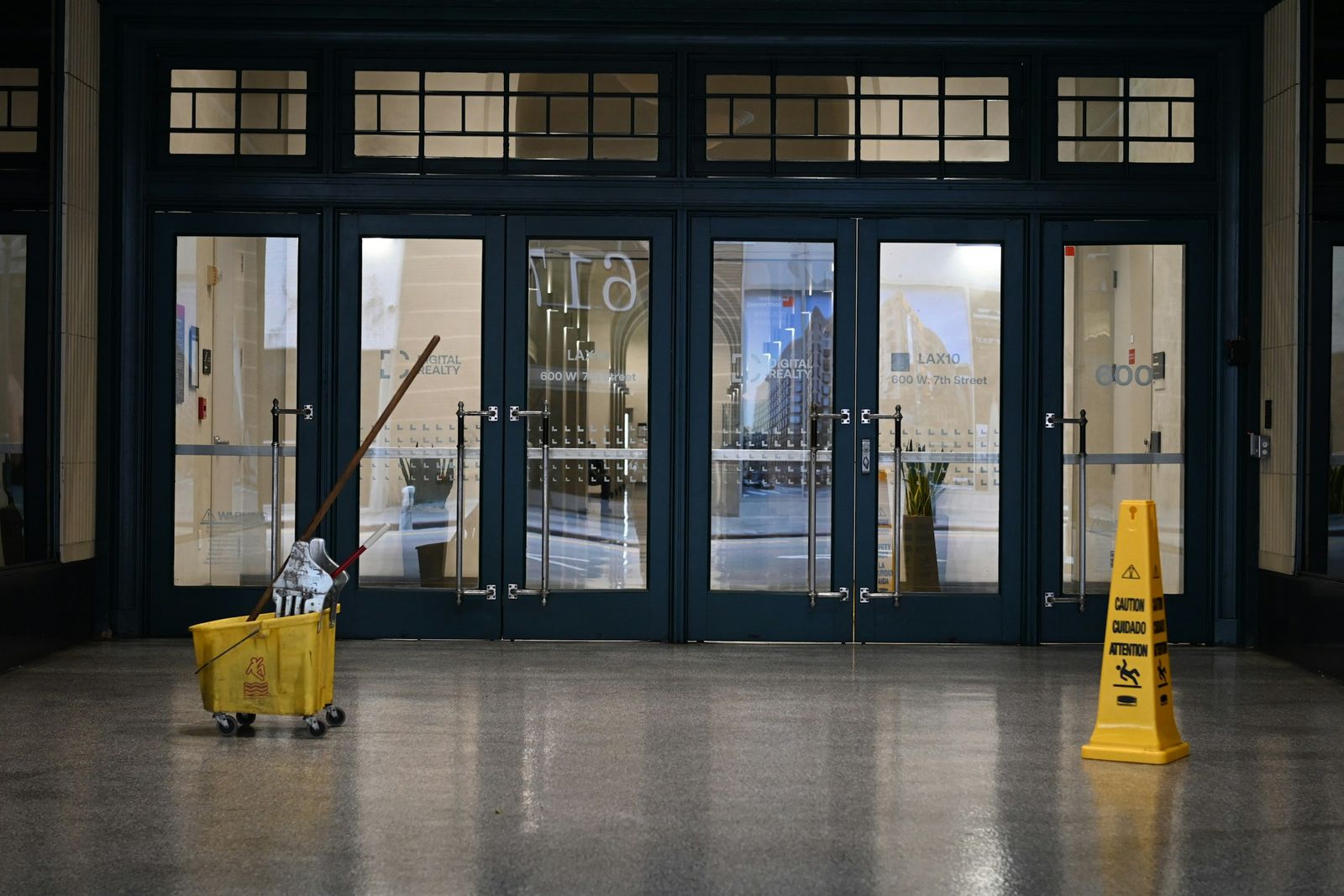 Cubeta y aviso de piso mojado en la entrada de un edificio
